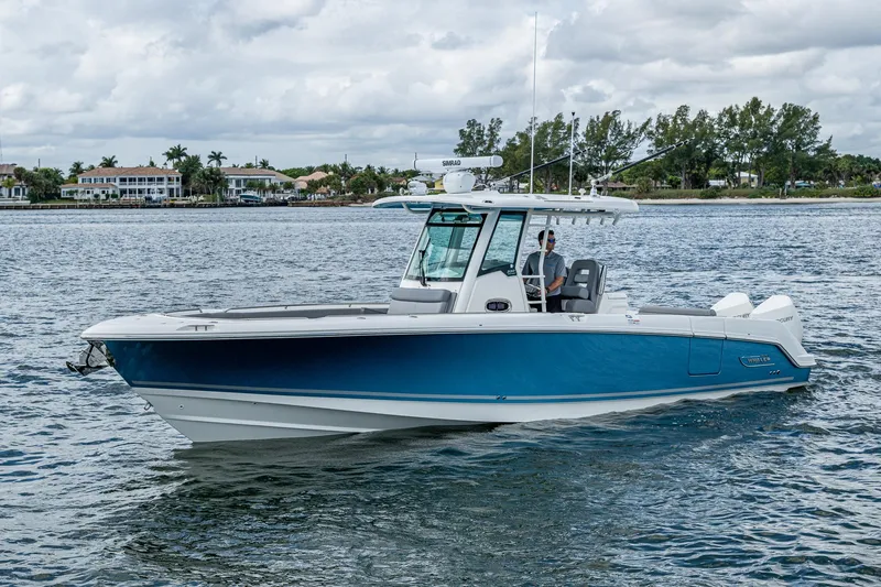 Slide: The Image of 2023 Boston Whaler 330 Outrage boat on calm water, showcasing sleek design and modern features. - 11