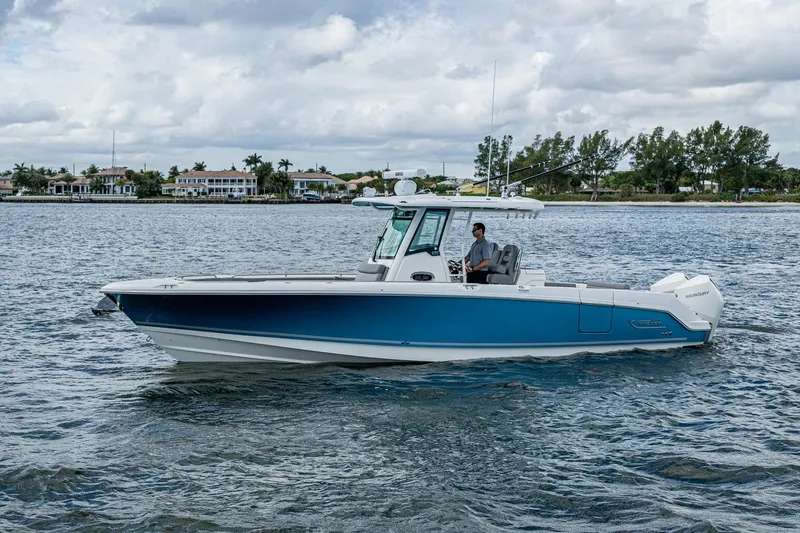 Slide: The Image of 2023 Boston Whaler 330 Outrage boat cruising on a calm waterway. - 12