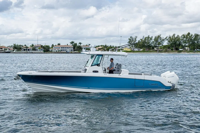 Slide: The Image of 2023 Boston Whaler 330 Outrage boat cruising on a calm waterway. - 13