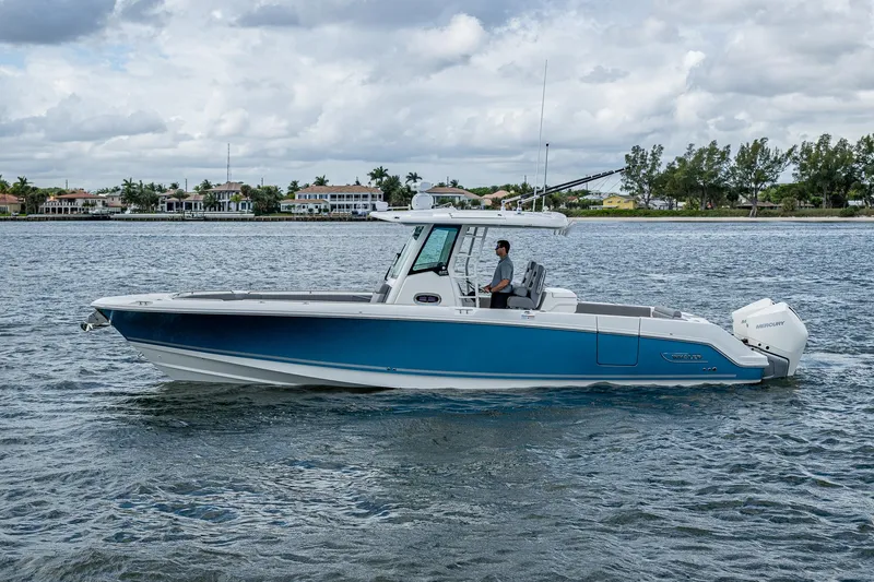Slide: The Image of 2023 Boston Whaler 330 Outrage boat cruising on a calm waterway. - 14