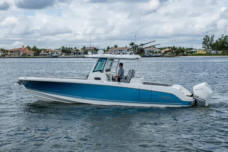 Slide: The Image of 2023 Boston Whaler 330 Outrage boat cruising on a calm waterway. - 15