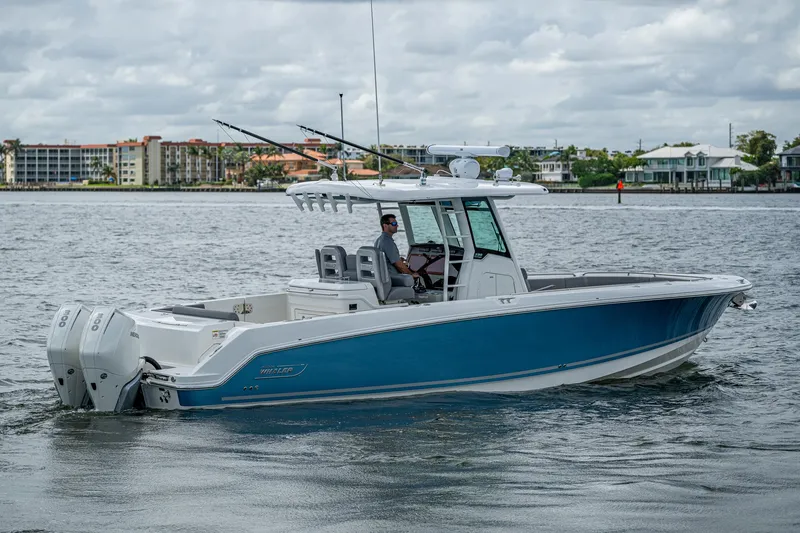 Slide: The Image of 2023 Boston Whaler 330 Outrage boat on calm water, featuring sleek design and dual engines. - 21
