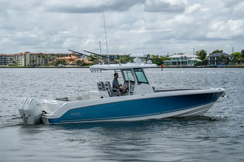Slide: The Image of 2023 Boston Whaler 330 Outrage boat cruising on a calm waterway. - 22