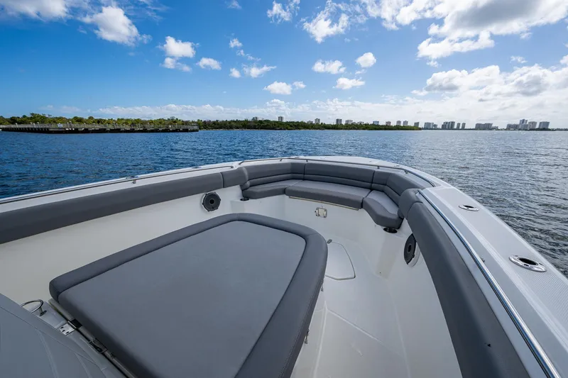 Slide: The Image of 2023 Boston Whaler 330 Outrage boat interior with cushioned seating, on a sunny day. - 24