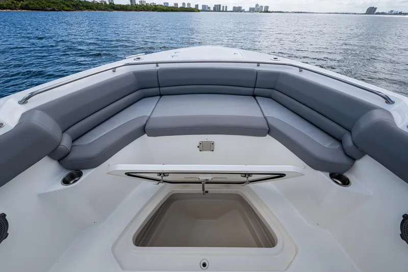 Slide: The Image of 2023 Boston Whaler 330 Outrage boat with spacious seating and storage, on calm water. - 26