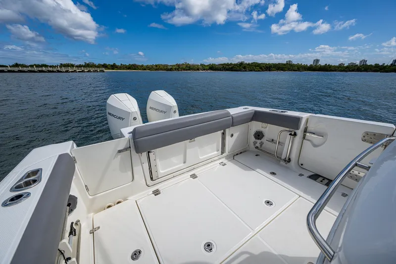 Slide: The Image of 2023 Boston Whaler 330 Outrage boat deck with twin engines on a sunny day. - 33