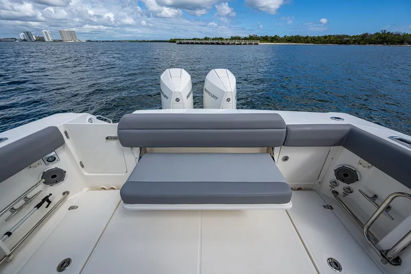 Slide: The Image of 2023 Boston Whaler 330 Outrage boat interior with seating and twin engines on a calm sea. - 35