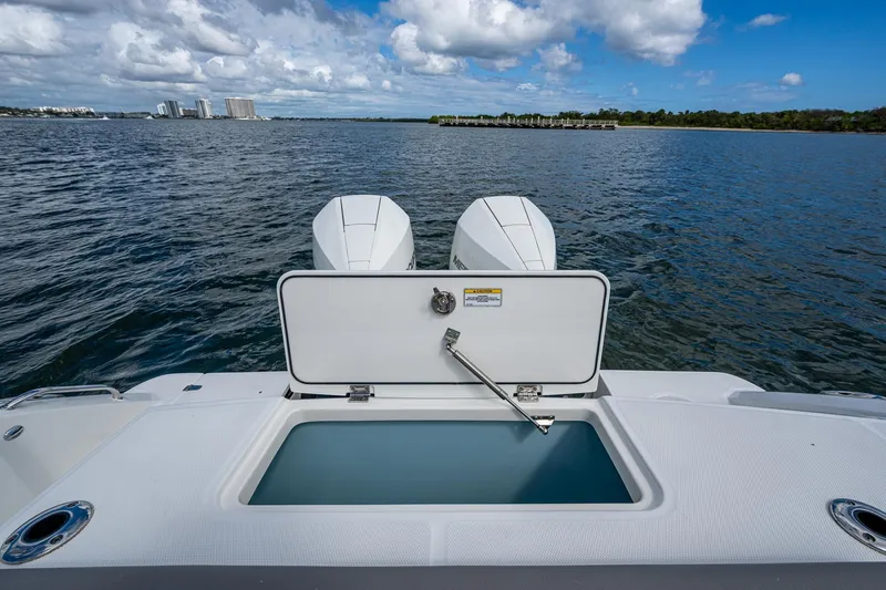 Slide: The Image of 2023 Boston Whaler 330 Outrage boat with open storage compartment on calm water. - 36