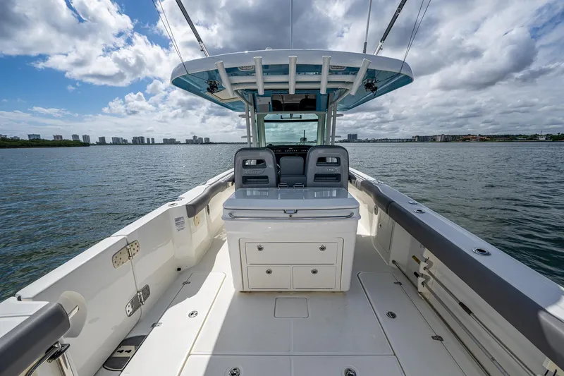 Slide: The Image of 2023 Boston Whaler 330 Outrage boat on water, featuring spacious deck and modern design. - 38