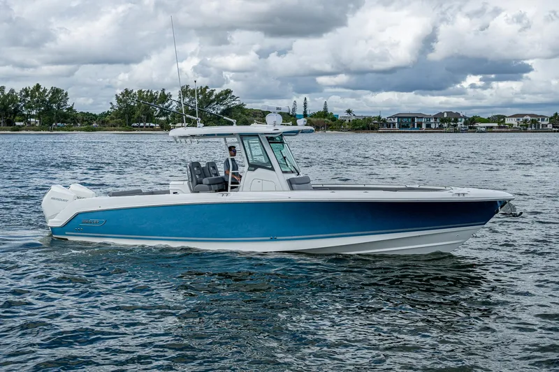 Slide: The Image of 2023 Boston Whaler 330 Outrage boat cruising on a scenic waterway. - 4