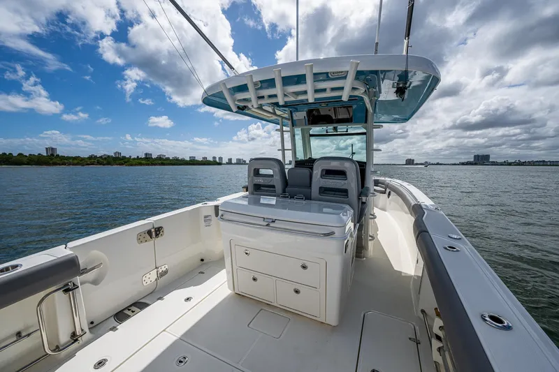 Slide: The Image of 2023 Boston Whaler 330 Outrage boat on calm water under a partly cloudy sky. - 40