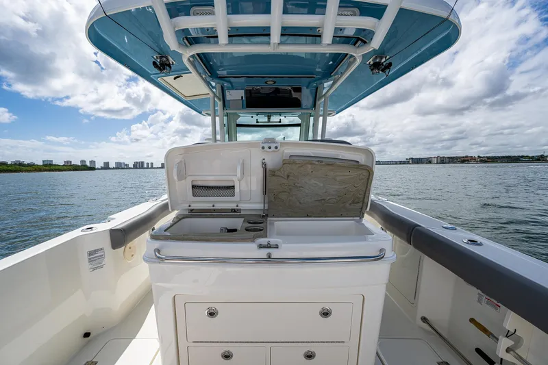 Slide: The Image of 2023 Boston Whaler 330 Outrage boat interior with open storage compartment on a sunny day. - 42