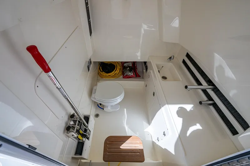 Slide: The Image of 2023 Boston Whaler 330 Outrage interior with toilet and storage space. - 46