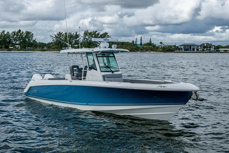 Slide: The Image of 2023 Boston Whaler 330 Outrage boat on water, cloudy sky background. - 5
