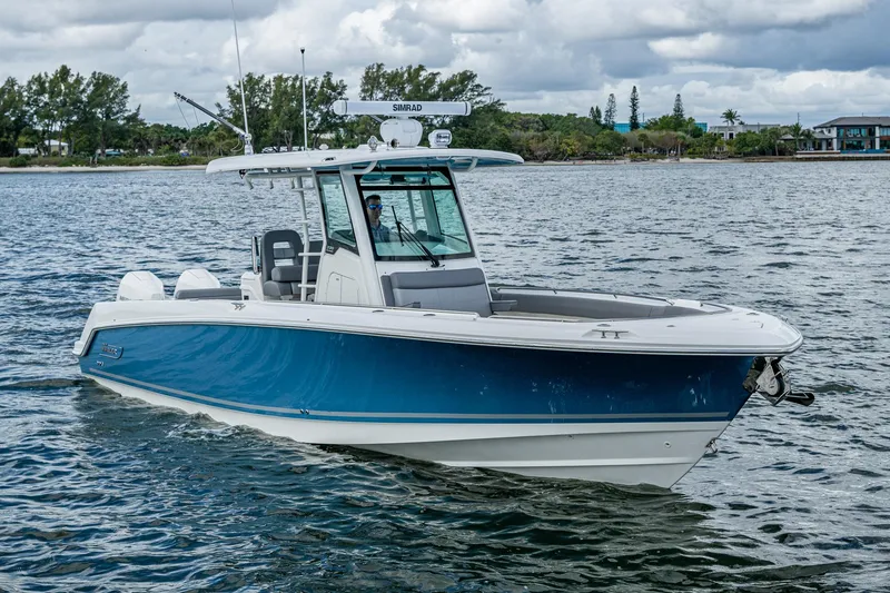 Slide: The Image of 2023 Boston Whaler 330 Outrage boat cruising on a calm waterway. - 6