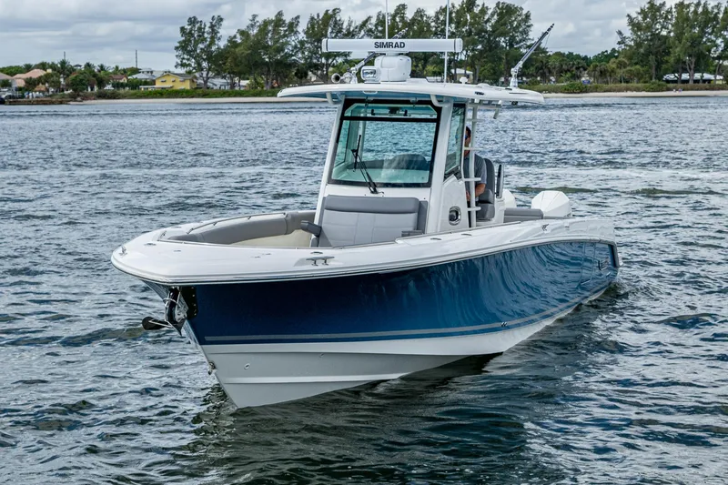 Slide: The Image of 2023 Boston Whaler 330 Outrage boat cruising on a calm waterway. - 8