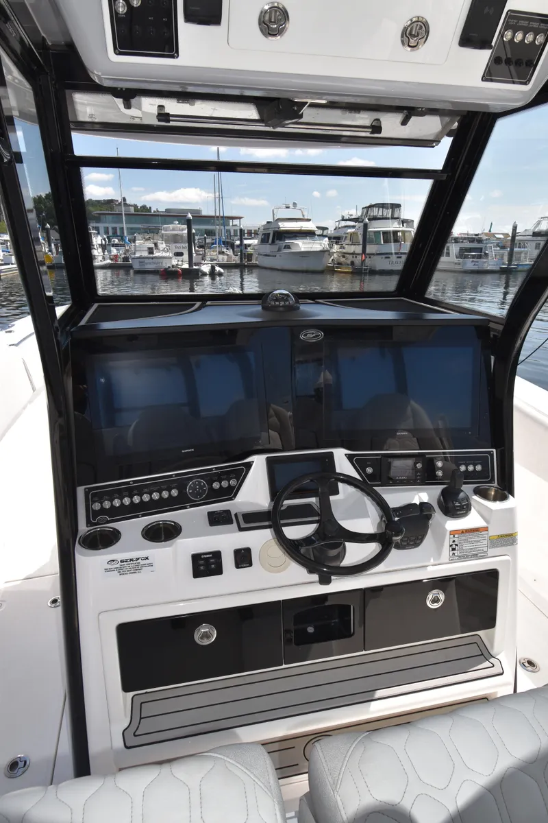 Slide: The Image of 2021 Sea Fox 368 boat dashboard with steering wheel and navigation controls at marina. - 9