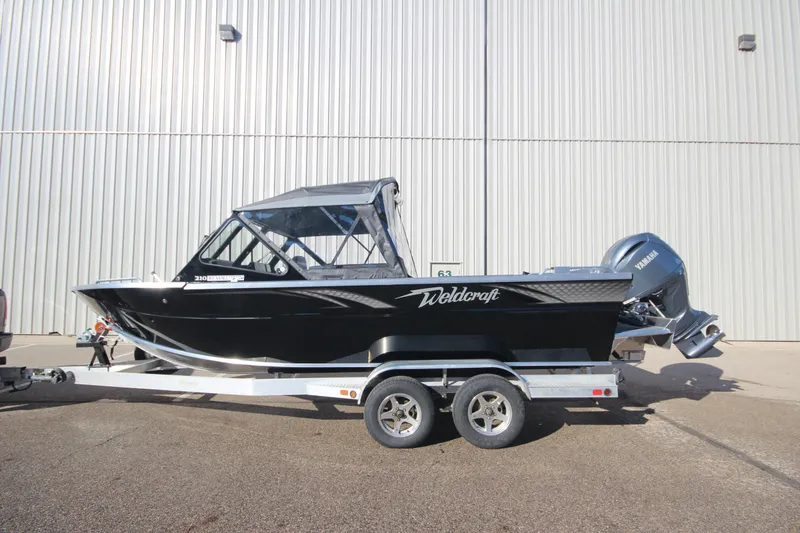 Slide: The Image of 2025 Weldcraft 210 Revolution Soft Top boat on trailer, side view. - 0
