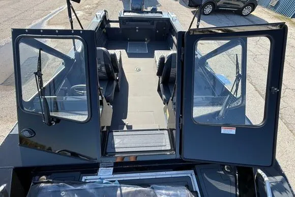 Slide: The Image of 2025 Weldcraft 210 Revolution boat interior with open doors, showcasing seating and deck layout. - 17