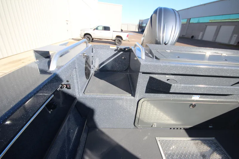 Slide: The Image of 2025 Weldcraft 210 Revolution Soft Top boat interior with storage compartments and motor. - 15