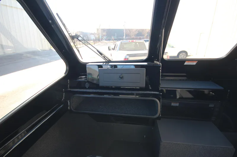 Slide: The Image of Interior view of 2025 Weldcraft 210 Revolution Soft Top boat, featuring dashboard and storage compartments. - 25