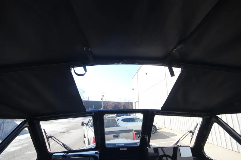 Slide: The Image of Interior view of 2025 Weldcraft 210 Revolution Soft Top boat, showcasing windshield and dashboard. - 30