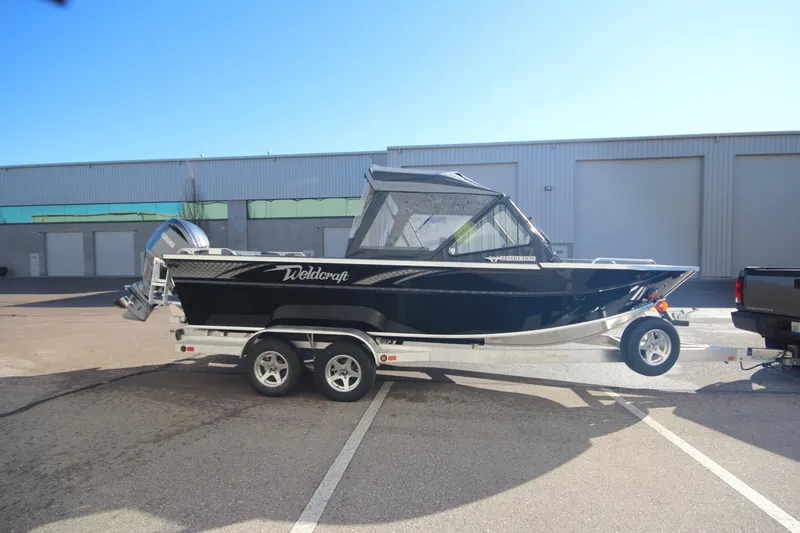 Slide: The Image of 2025 Weldcraft 210 Revolution Soft Top boat on trailer in parking lot. - 5