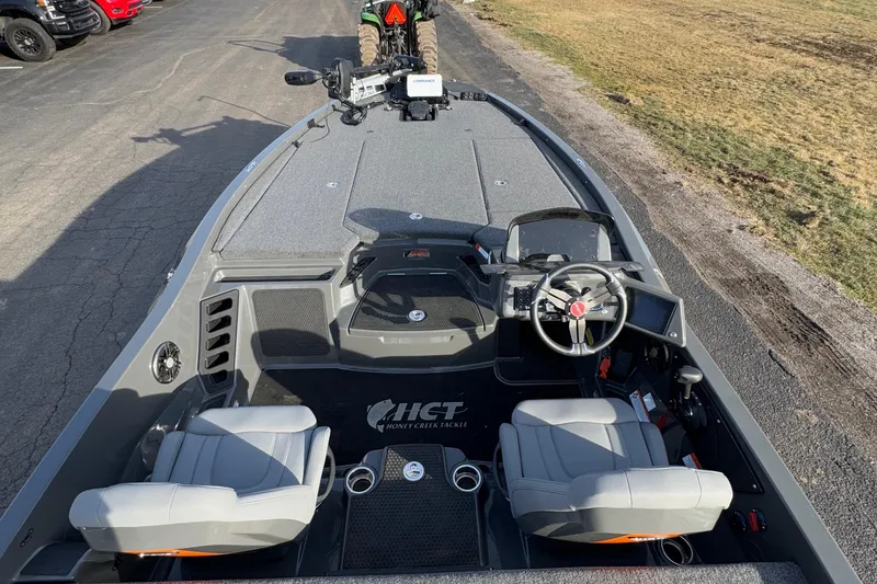 Slide: The Image of 2024 iKon LX20 boat interior with steering wheel, seats, and dashboard on a paved road. - 13