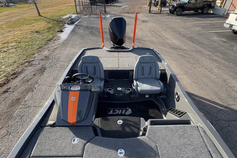 Slide: The Image of 2024 iKon LX20 boat interior with dual seats and steering console, parked outdoors. - 17