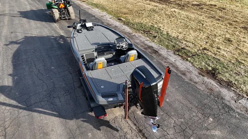 Slide: The Image of 2024 iKon LX20 boat on trailer, parked on a rural road. - 3