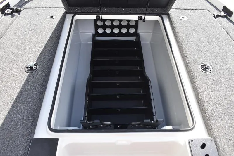 Slide: The Image of 2025 Triton 19 TrX Patriot boat storage compartment with organized tackle trays. - 13