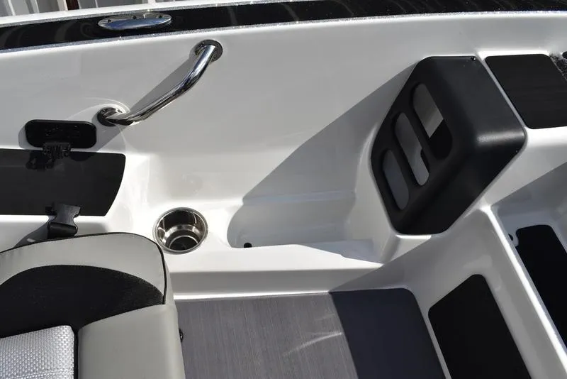 Slide: The Image of Interior of 2025 Triton 19 TrX Patriot boat, featuring seating and cup holder. - 19
