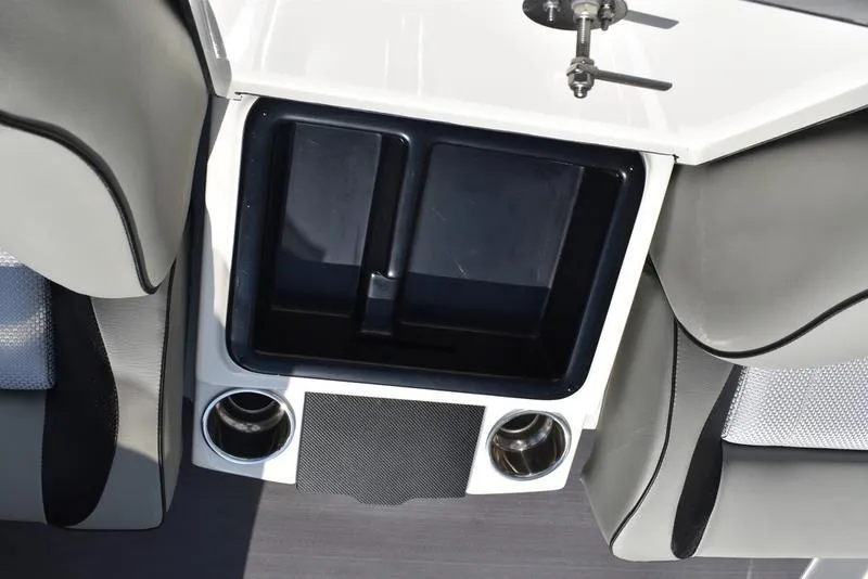 Slide: The Image of 2025 Triton 19 TrX Patriot boat interior with storage compartment and cup holders. - 21