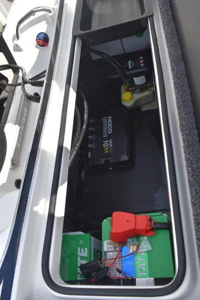 Slide: The Image of 2025 Triton 19 TrX Patriot boat battery compartment with wiring and components. - 29