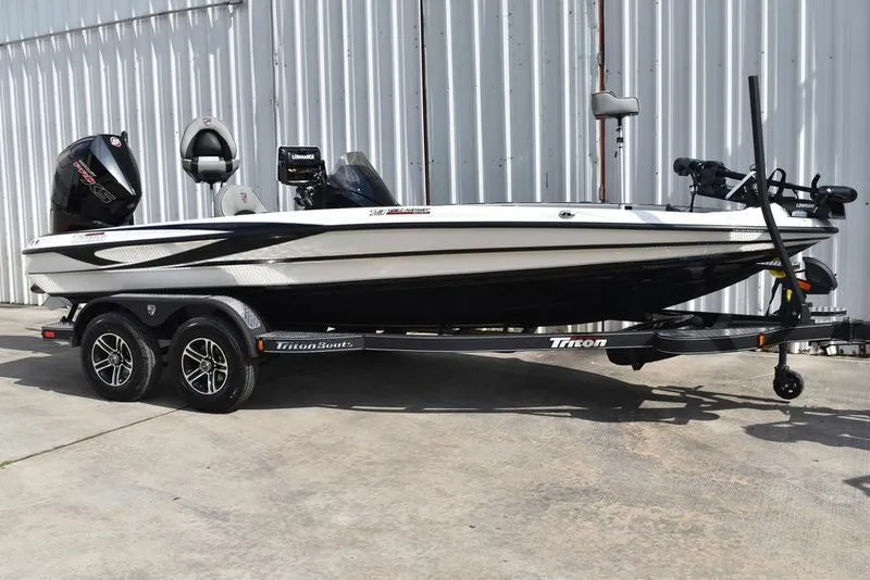 Slide: The Image of 2025 Triton 19 TrX Patriot boat on trailer, parked outdoors. - 3