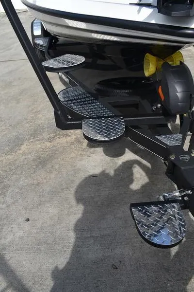 Slide: The Image of 2025 Triton 19 TrX Patriot boat trailer with diamond plate steps. - 5