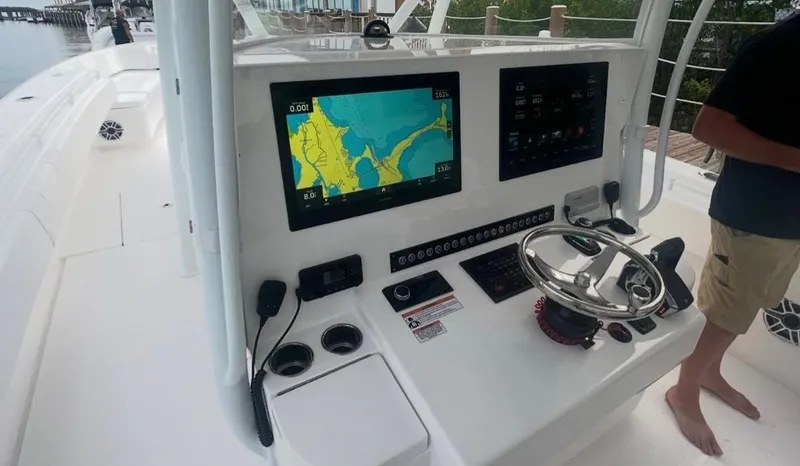 Slide: The Image of 2023 Contender 44 ST boat dashboard with navigation screens and steering wheel. - 4