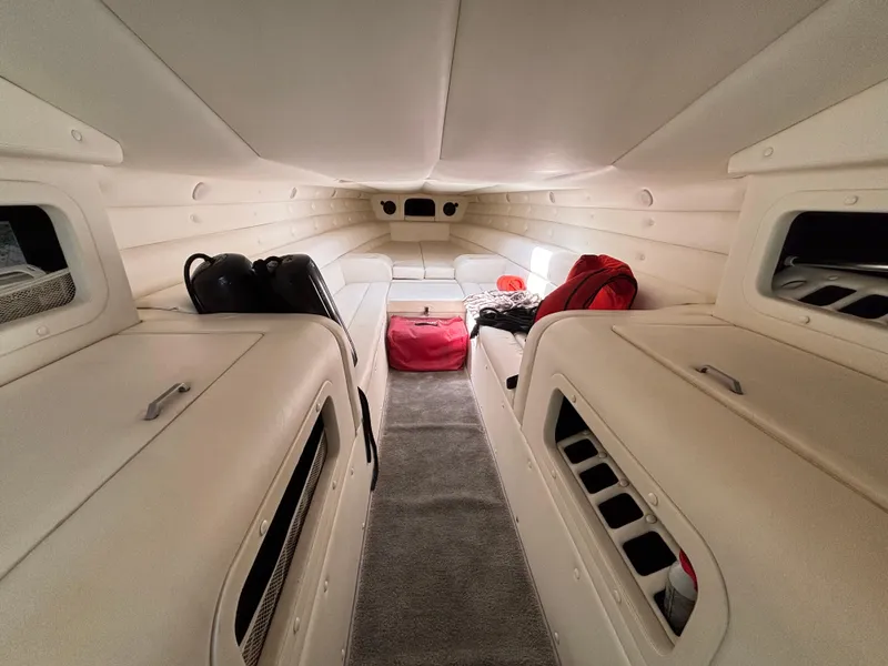 Slide: The Image of Interior of a 1994 Apache 47 Fire Water boat, featuring white seating and storage compartments. - 17