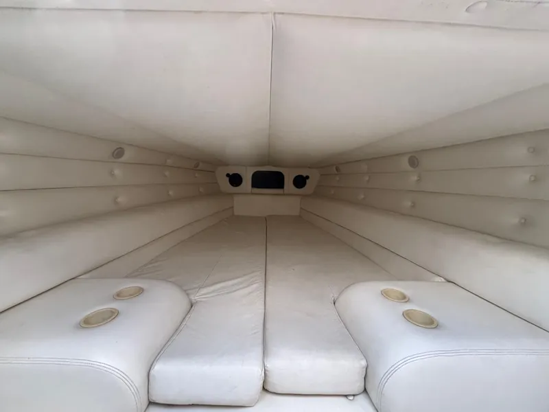 Slide: The Image of Interior cabin of a 1994 Apache 47 Fire Water boat, featuring white cushioned seating. - 18