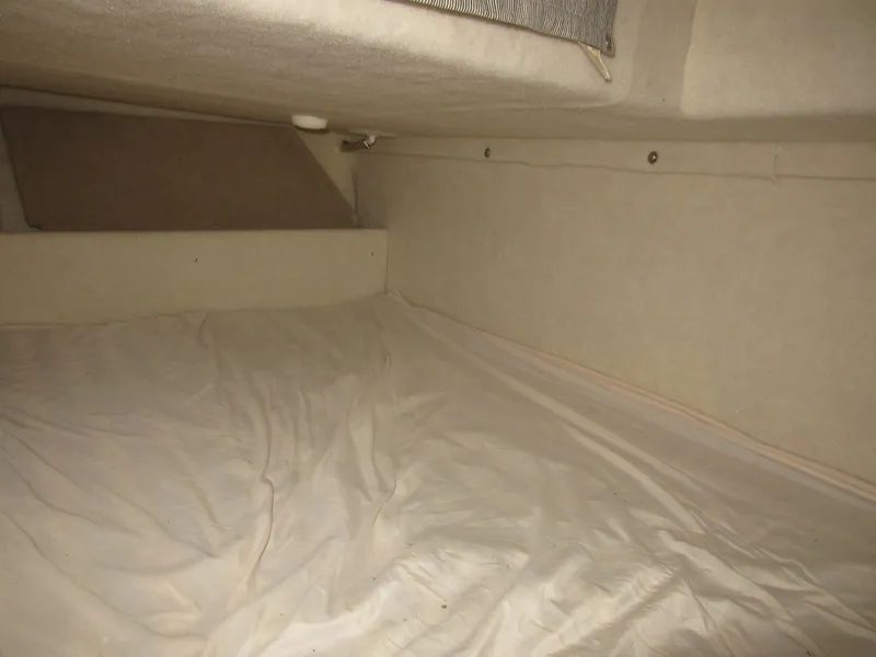 Slide: The Image of Interior cabin of a 2004 Bayliner 245 boat, featuring a cozy sleeping area. - 18