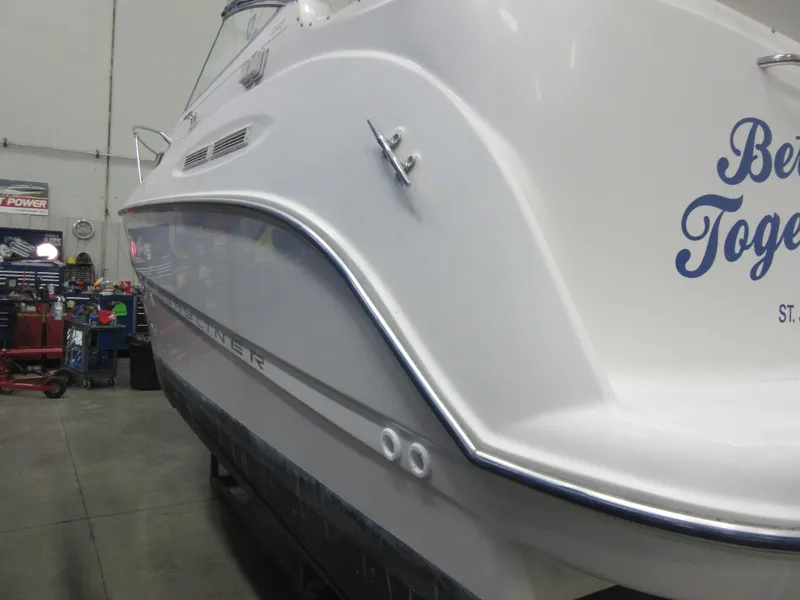 Slide: The Image of 2004 Bayliner 245 boat in a garage, showcasing sleek white hull design. - 21