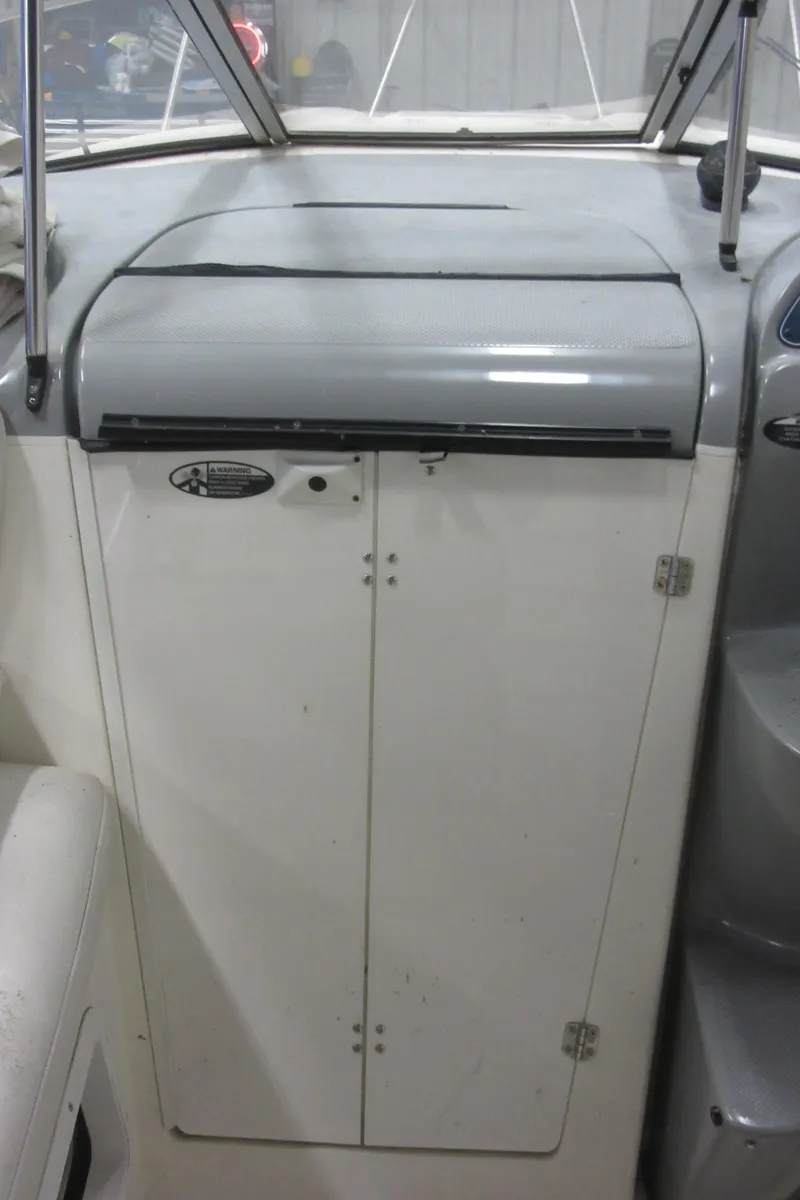 Slide: The Image of 2004 Bayliner 245 boat interior dashboard and storage compartment. - 23