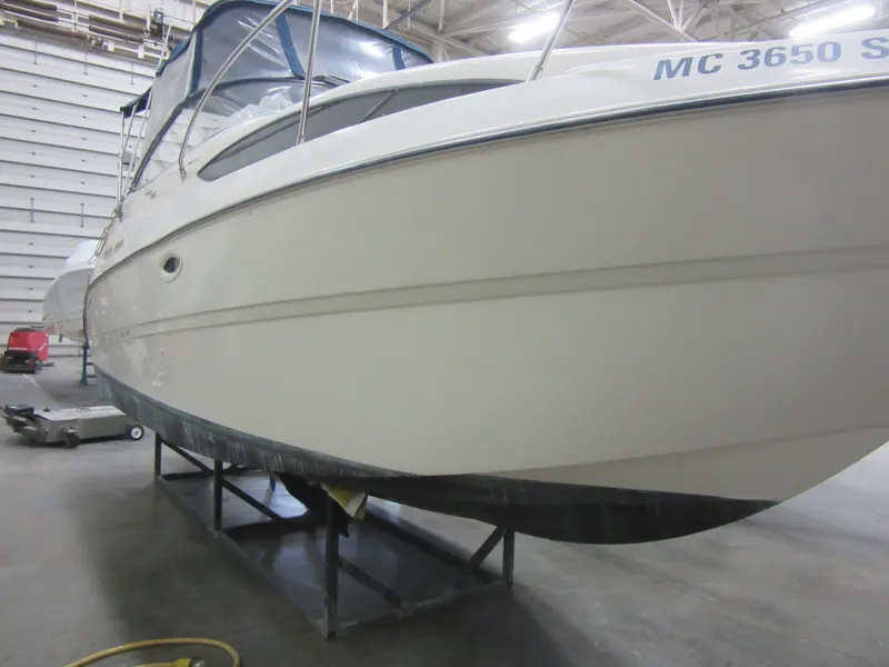 Slide: The Image of 2004 Bayliner 245 boat in storage, side view, indoors. - 3