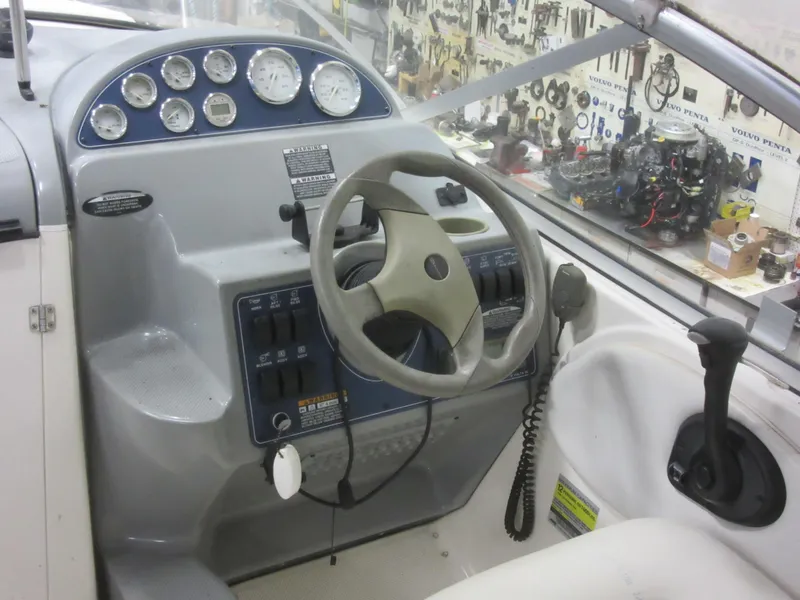 Slide: The Image of 2004 Bayliner 245 boat dashboard with steering wheel and control panel. - 7