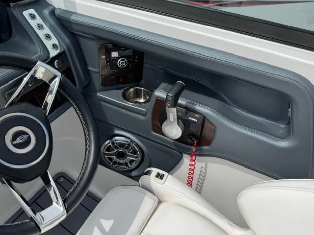 Slide: The Image of 2021 Chaparral 267 SSX OB boat interior with steering wheel, controls, and cup holder. - 11