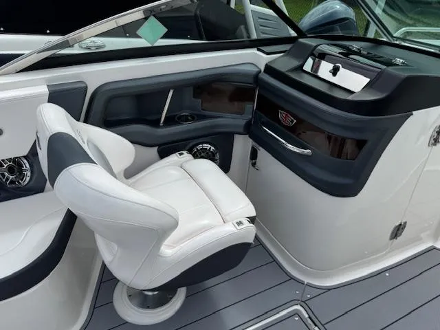 Slide: The Image of 2021 Chaparral 267 SSX OB boat interior with white captain's chair and sleek dashboard. - 12