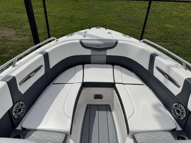 Slide: The Image of 2021 Chaparral 267 SSX OB boat interior with white and gray seating, outdoor setting. - 4