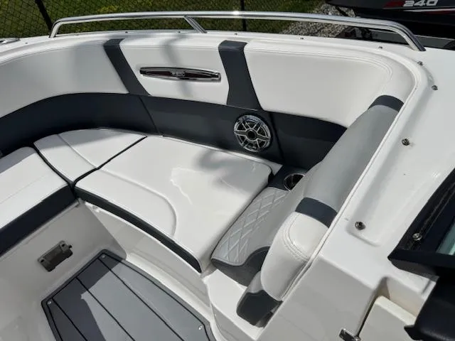Slide: The Image of 2021 Chaparral 267 SSX OB boat interior with white and gray seating, speaker, and railing. - 5