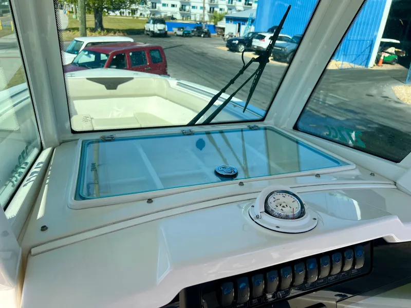 Slide: The Image of 2023 Sailfish 272 CC boat dashboard with compass and windshield wipers. - 11
