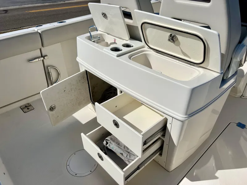 Slide: The Image of 2023 Sailfish 272 CC boat interior with open storage compartments and sink. - 22